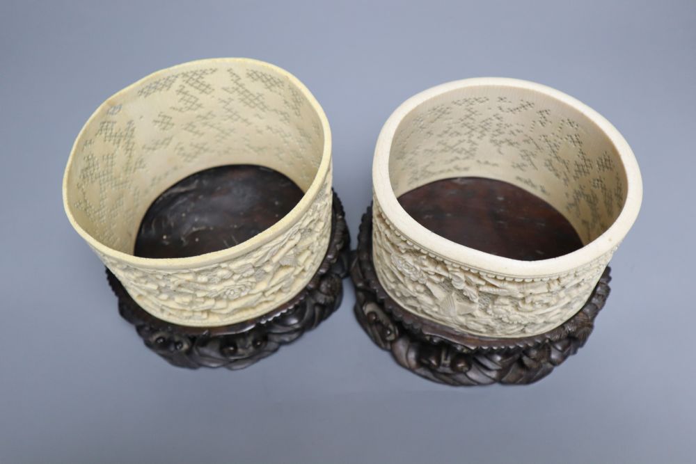 A pair of early 20th century Chinese ivory pots, with carved wood stands, overall height 16cm